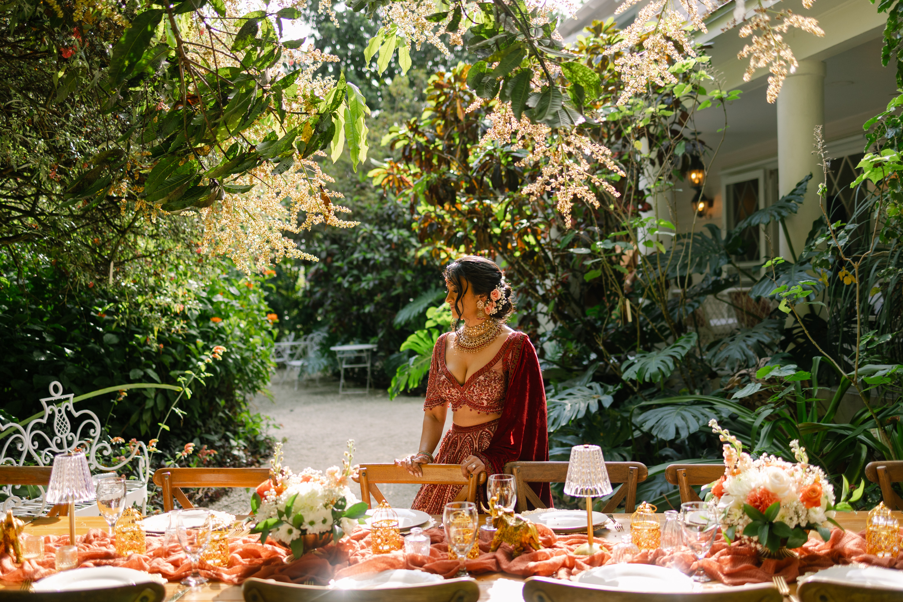 Bride wearing real flowers in her hair at a garden wedding table