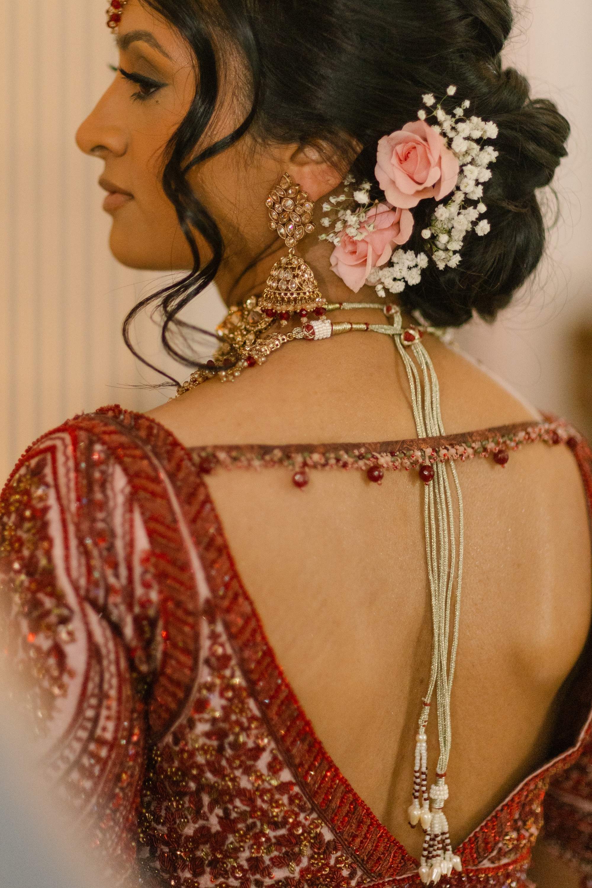bridal updo with real flower pink roses and baby’s breath in wedding hair