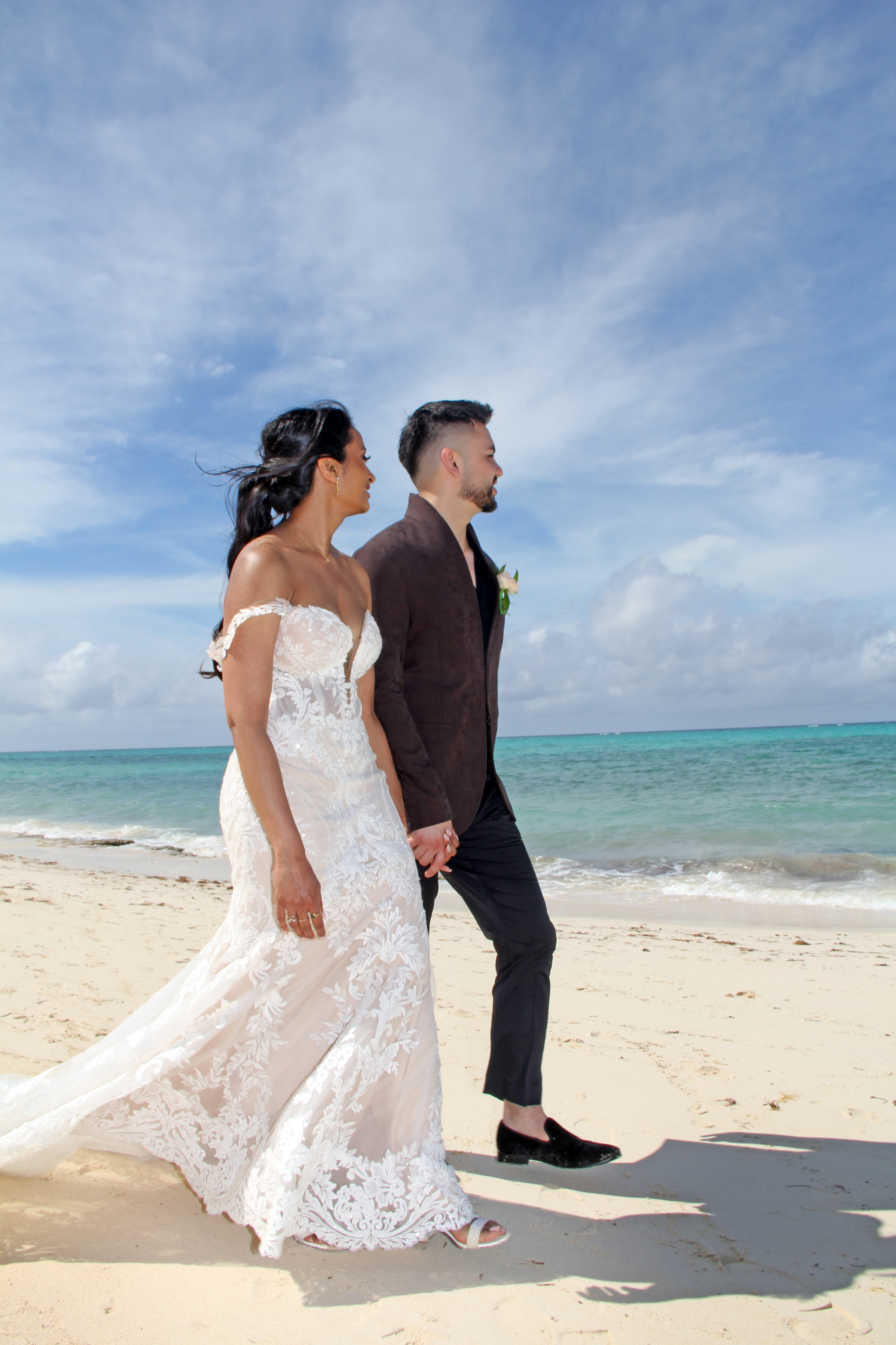 Bride and groom walking together along the beach after their wedding ceremony in Nassau, Bahamas.